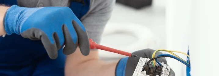 Person montiert Steckdose mit Schraubendreher.